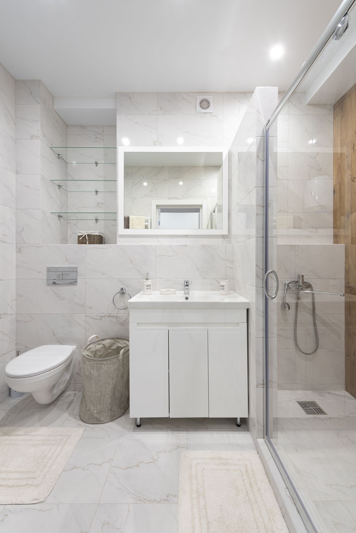 A bright, modern home bathroom with a washbasin and shower.